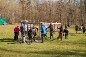 grupa kobiet i mężczyzn na łące na tle tarcz łuczniczych